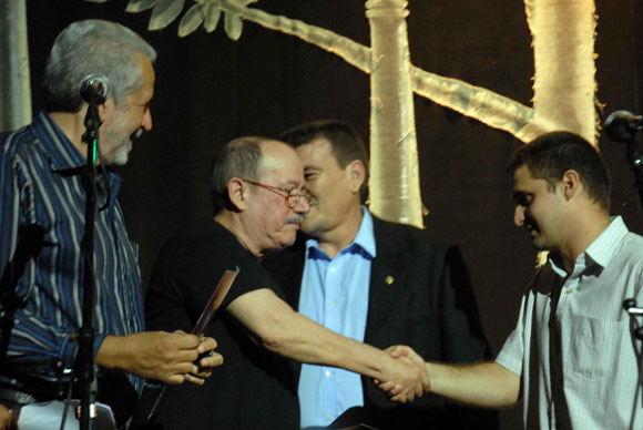 Gilberto Tabares (D), presidente de la Federación Estudiantil Universitaria (FEU), saluda al cantautor Silvio Rodríguez ©, después de recibir la medalla 280 Aniversario de la Universidad de La Habana: A su lado Jorge Gómez (I), director del grupo Moncada, en el teatro América, en Ciudad de La Habana, el 10 de mayo de 2010. AIN Foto: Marcelino VAZQUEZ HERNANDE